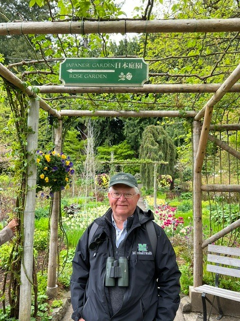 Dr. Gary Rankin stands beneath the entrance to a rose garden during one of the couple's horticultural travels.