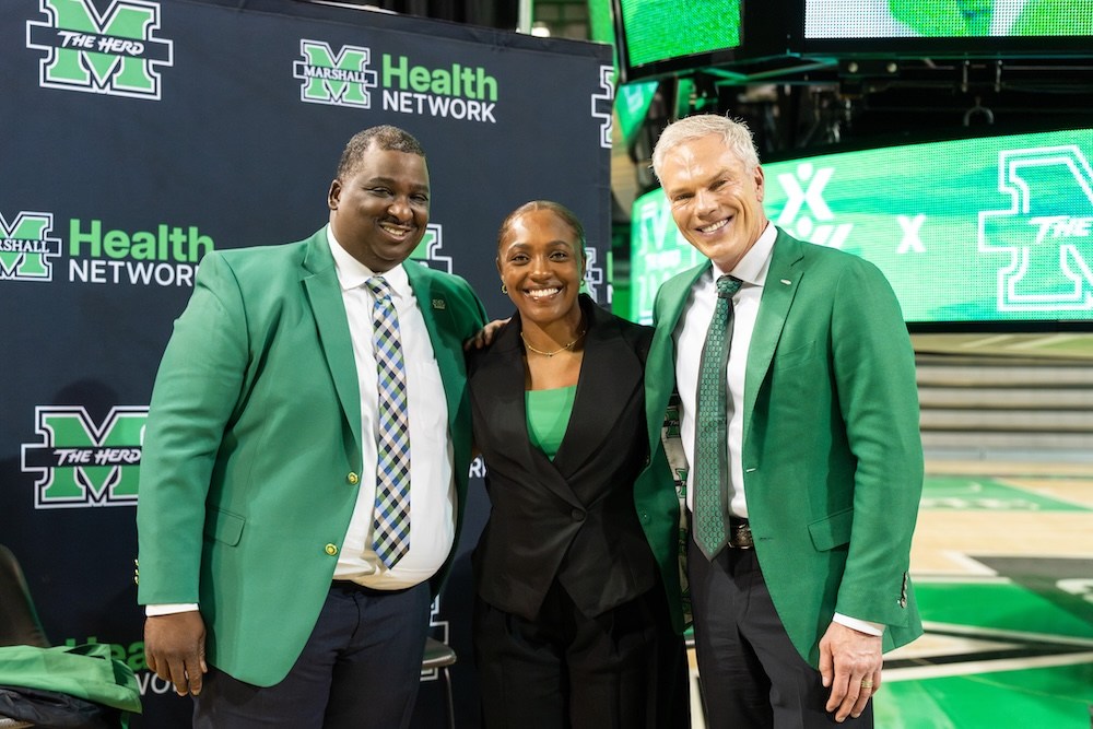 Marshall University Director of Athletics Gerald Harrison, Head STUNT Coach Evynn Richard and Marshall University President Brad D. Smith pose together during Richard's introductory press conference inside the Cam Henderson Center.