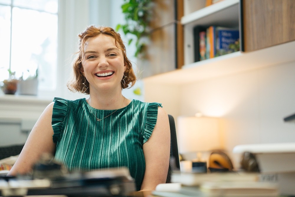 Women's Center Coordinator Alissa Rookard smiles while seated at her desk in the Marshall University Women's Center office.