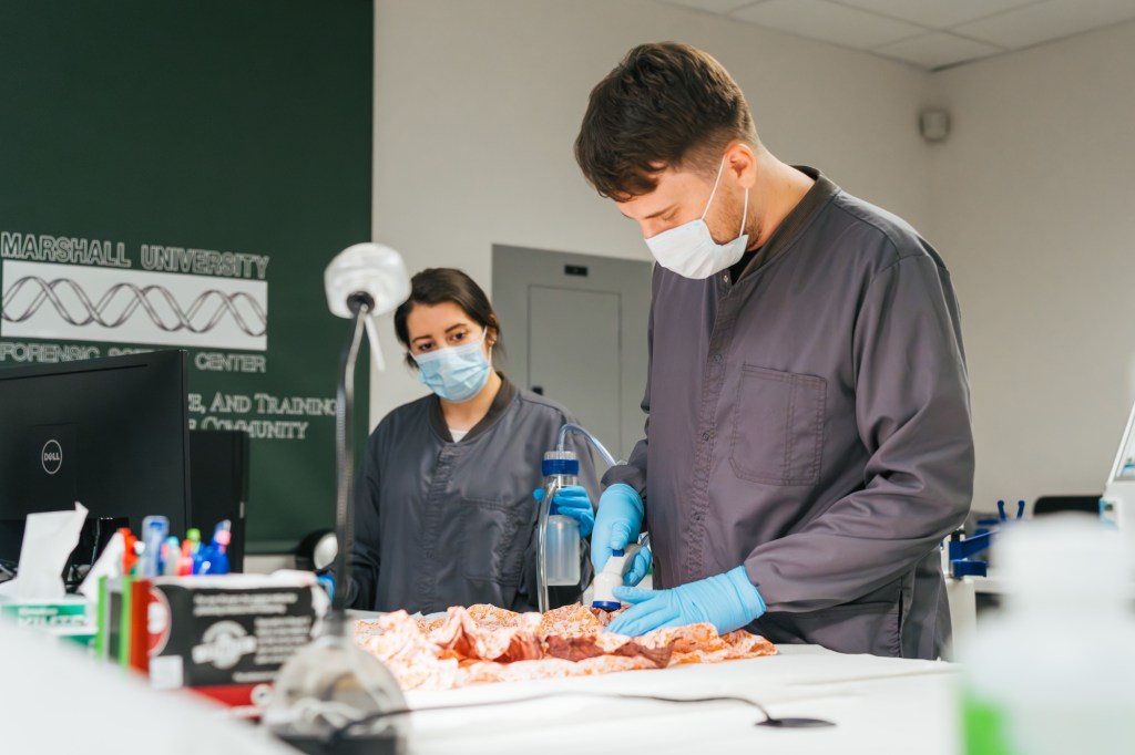 students working in the Forensic Science Center wearing masks